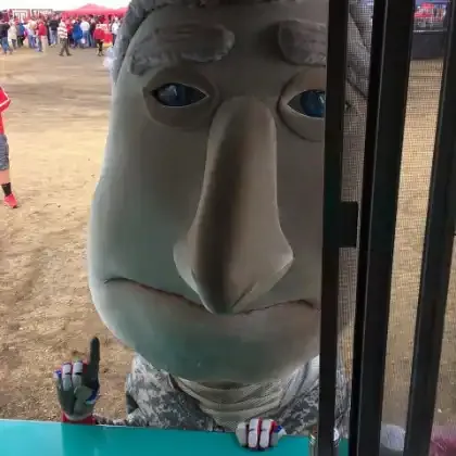 The racing-president mascot George peeking into the truck's service window at an event.