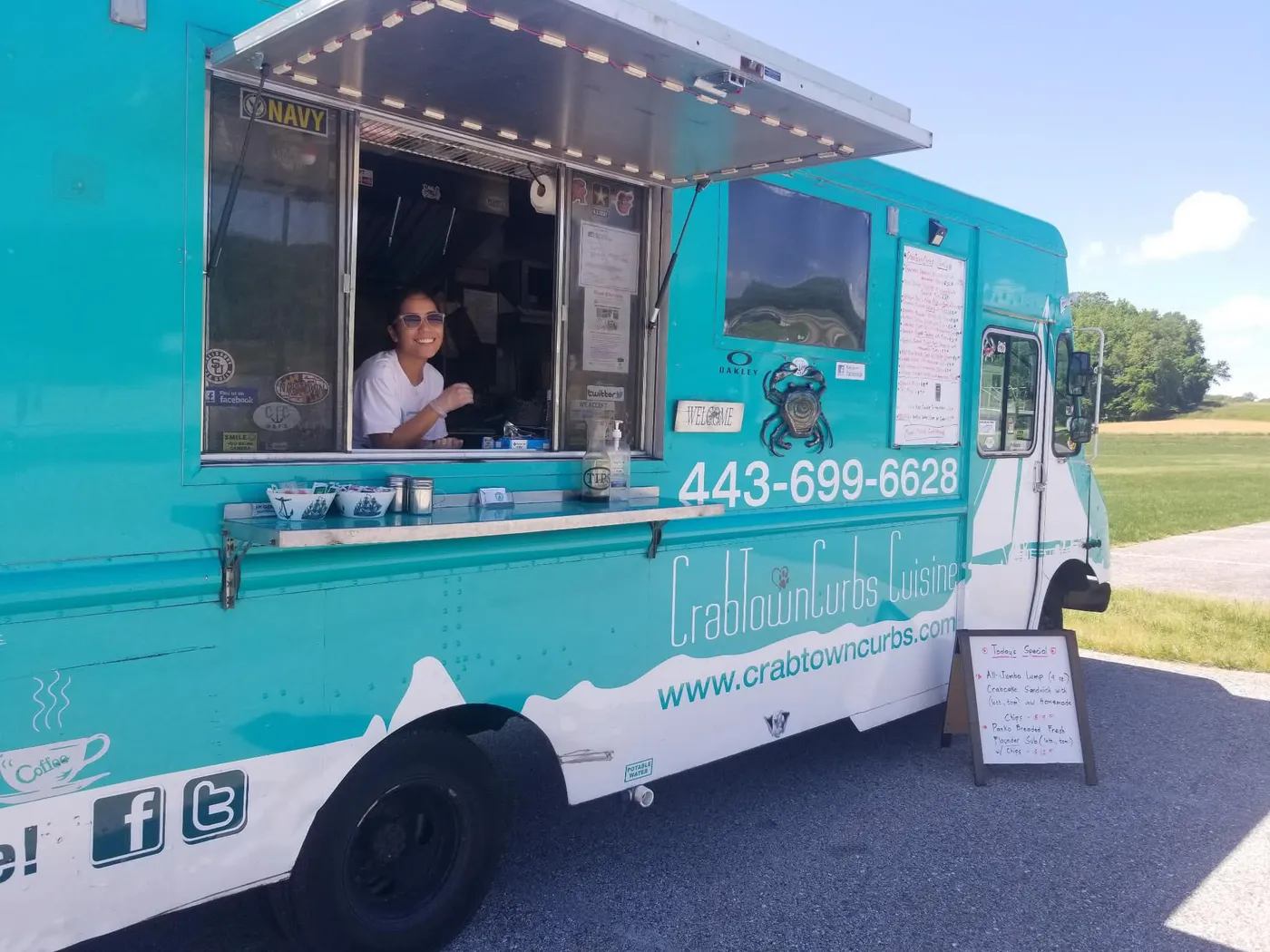 The owner's wife smiling at the service window of the CrabTown Curbs truck
