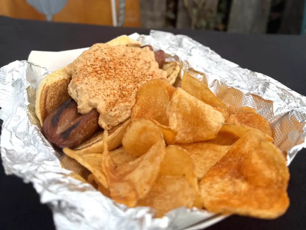All-beef hotdog topped with crabdip and crab spice, served with chips